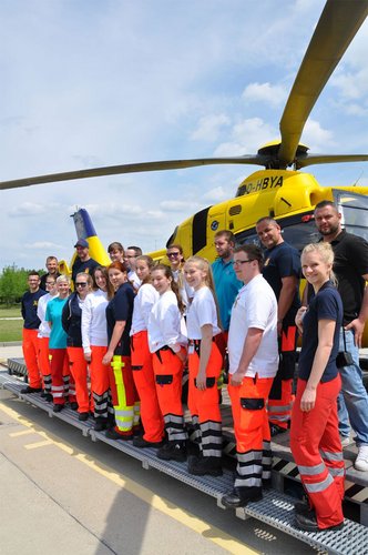 Gruppenbild von Rettungssanitätern Mit Hubschrauber im Hintergrund